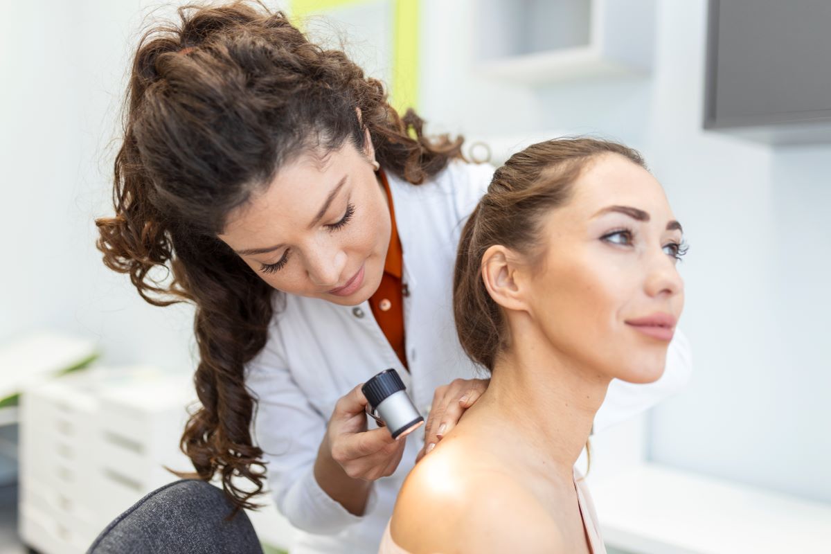 dermatologist latex gloves holding dermatoscope while examining attractive patient with skin disease female dermatologist examining patient with dermascope looking signs skin cancer